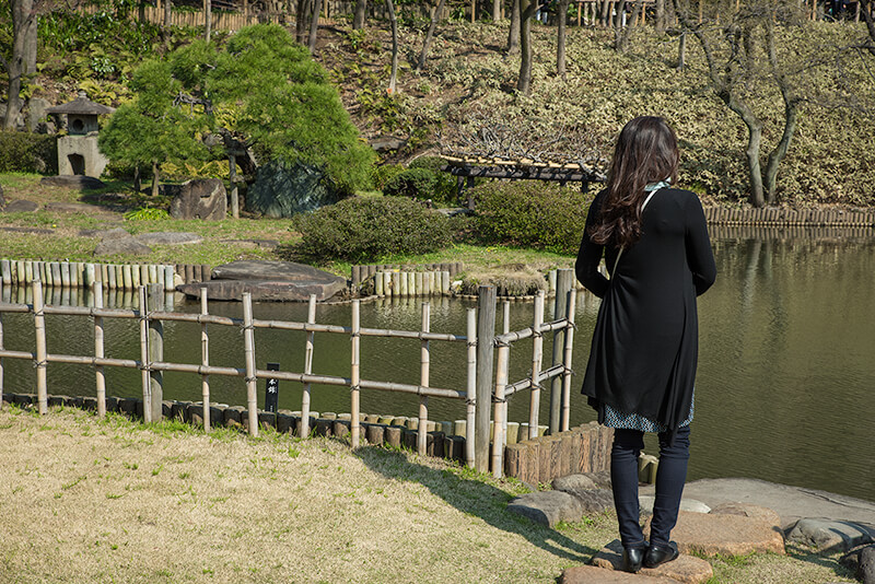 礼拝石から庭園を眺める女性