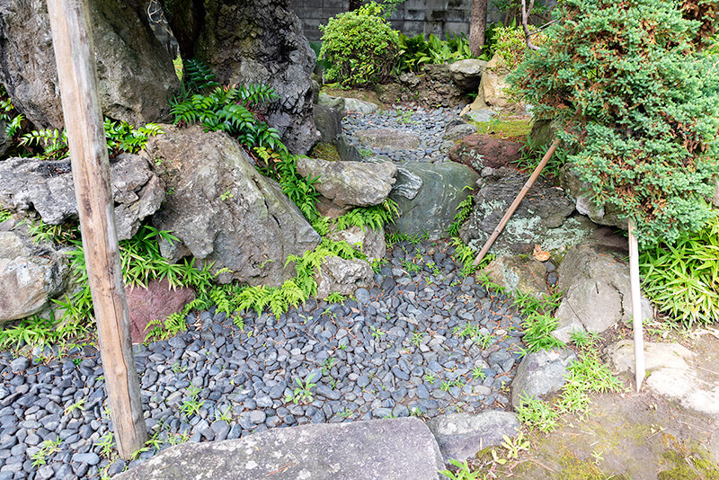 洞窟石組から水が湧き出て、池に流れ入る様子を石造りで表現