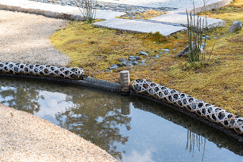 竹で編んだ筒に石を詰めている