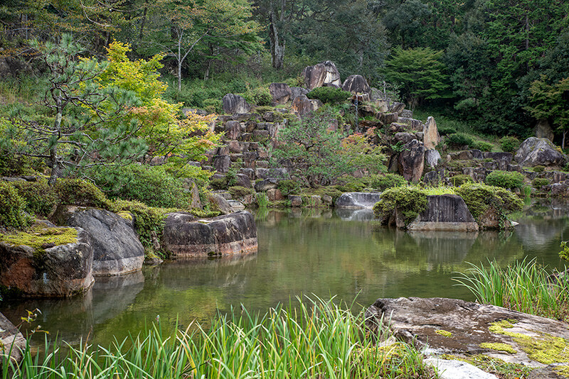 上段の池泉から滝石組と石垣を眺める